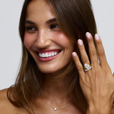 Two-tone oval diamond solitaire engagement ring with yellow and white gold band on hand