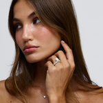 Side view of woman wearing Grace oval diamond ring showing warm 18ct yellow gold texture