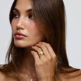 Lifestyle shot of horizontal emerald cut diamond ring stacked with plain gold band