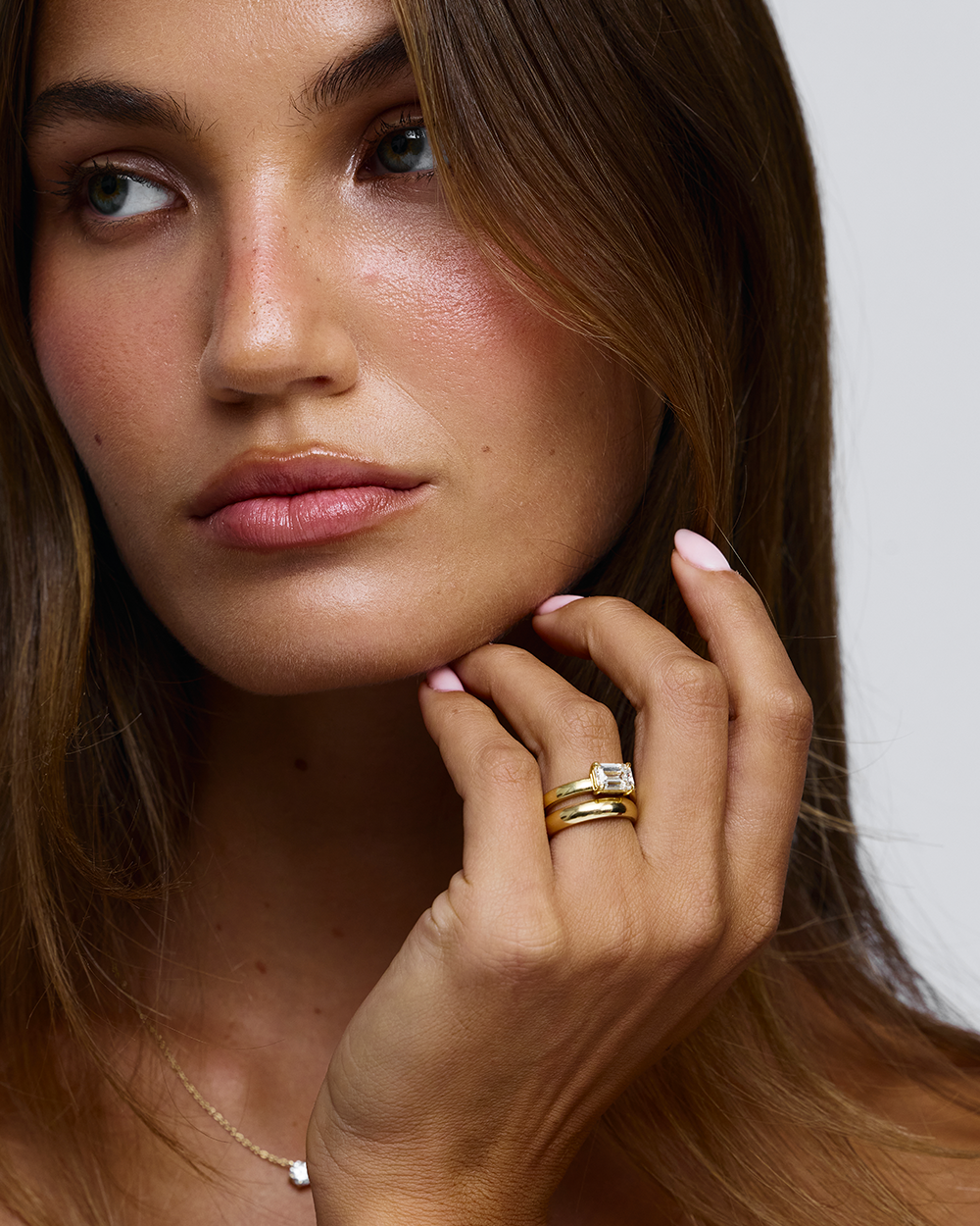 East west emerald cut diamond ring emphasizing slim tapered band and elongated finger look