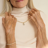 Gold chain necklace with faceted gemstone floral pendant on model