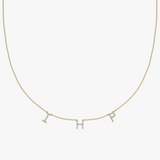 Yellow gold personalized charm necklace with diamond-encrusted initial letters I, H, and P