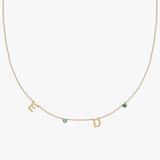 Solid gold personalised charm necklace with initials E and D, blue and green gemstones