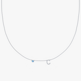Silver-toned charm necklace with blue gemstone and letter C pendant on delicate chain