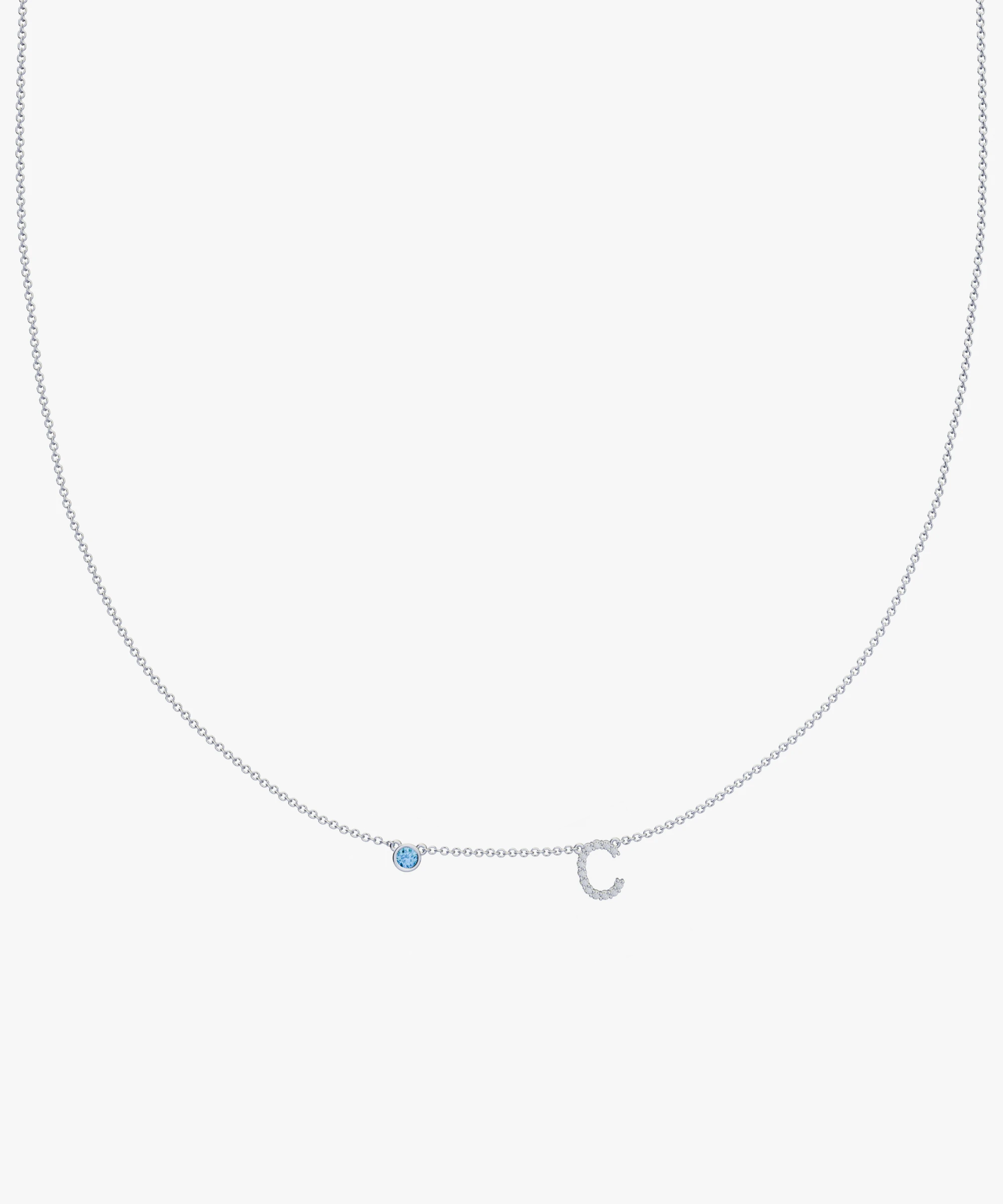 Silver-toned charm necklace with blue gemstone and letter C pendant on delicate chain