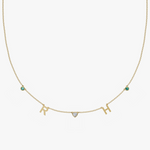 Yellow gold charm necklace with letter R and H initials, heart stone, and teal birthstone gems