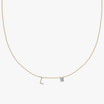 Yellow gold charm necklace with diamond initial L and blue birthstone pendant