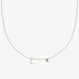 Yellow gold charm necklace with diamond initial L and blue birthstone pendant