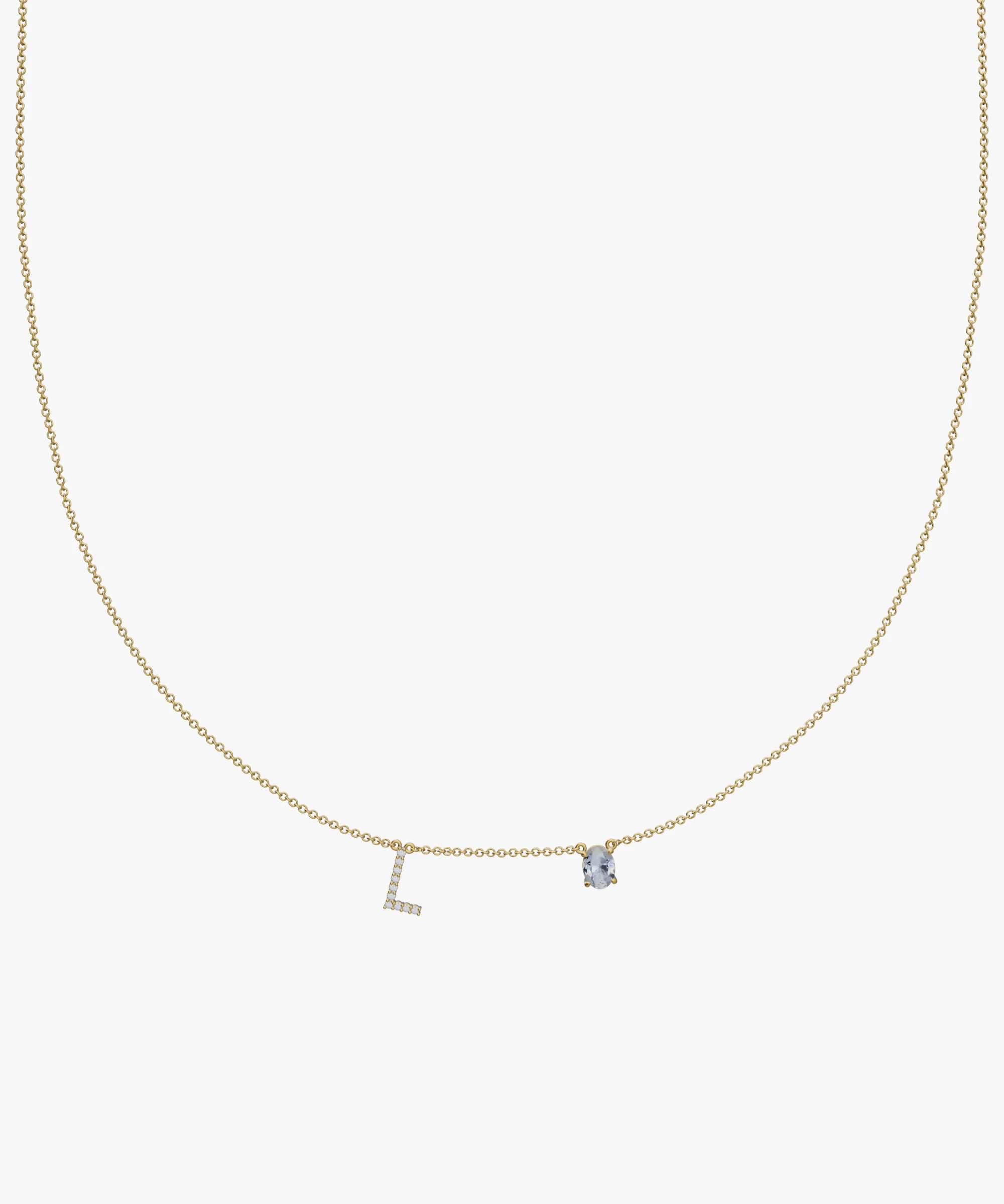 Yellow gold charm necklace with diamond initial L and blue birthstone pendant