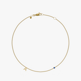 Yellow gold charm bracelet with initial 'A' and blue birthstone