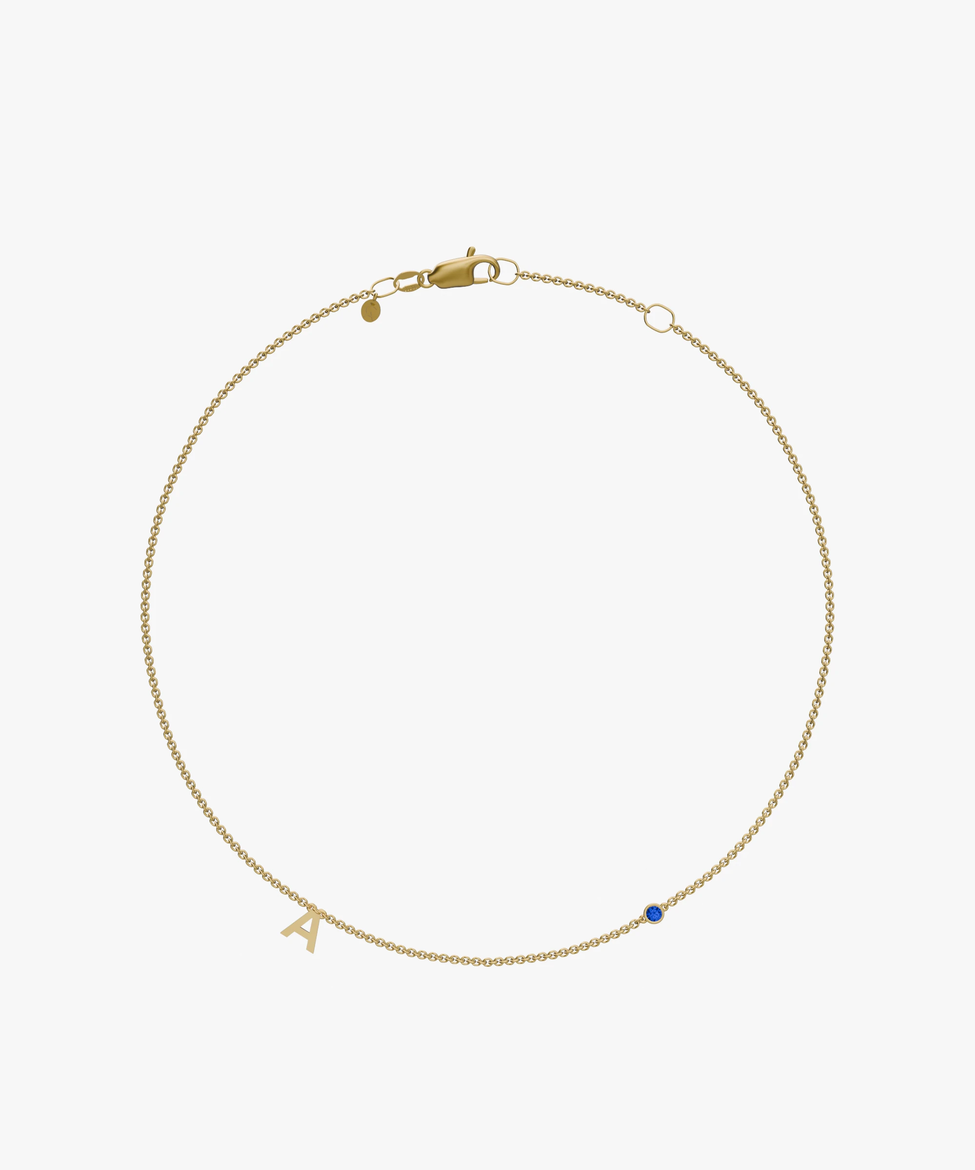 Yellow gold charm bracelet with initial 'A' and blue birthstone