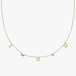 Yellow gold charm necklace with initial letters, green birthstone and floral diamond detail