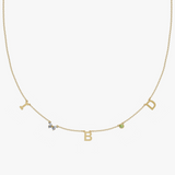 Yellow gold charm necklace with initial letters, green birthstone and floral diamond detail