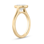 Side profile of 18ct yellow gold oval diamond bezel setting showing modern floating silhouette