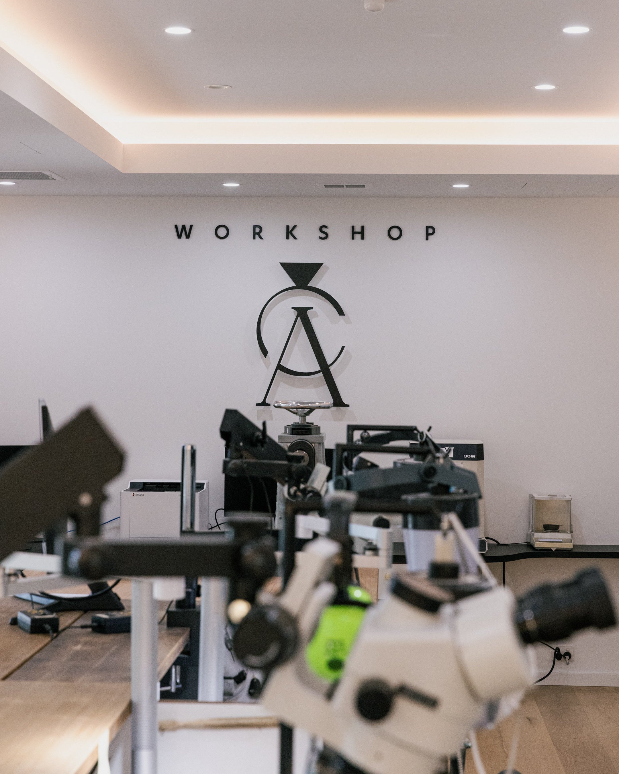 Interior of a workshop with equipment and a logo on the wall.