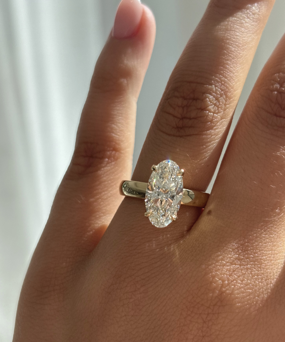 Harper oval lab grown diamond engagement ring on hand with 18ct yellow gold claw setting