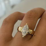 Close-up of tapered 18ct yellow gold band and four-prong marquise diamond setting