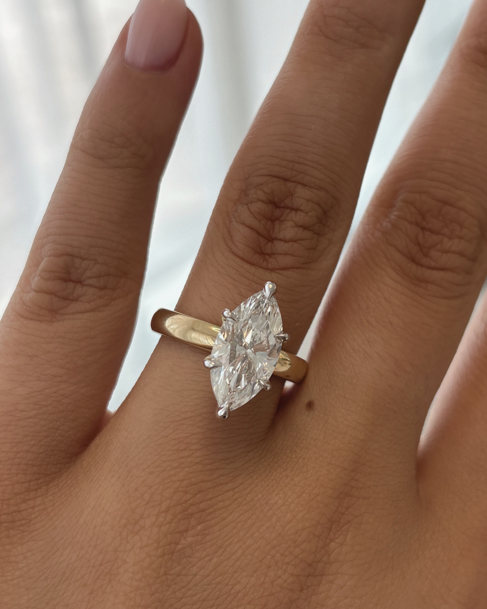 Side view of marquise cut diamond ring highlighting height and yellow to white gold transition