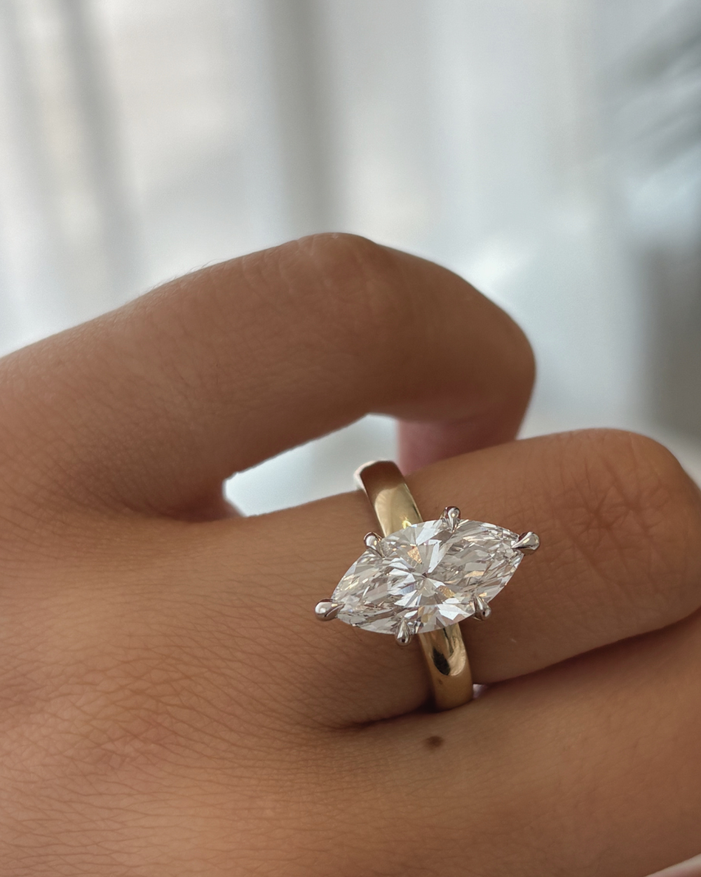 Marquise lab grown diamond ring on finger showing two-tone metal contrast and fit