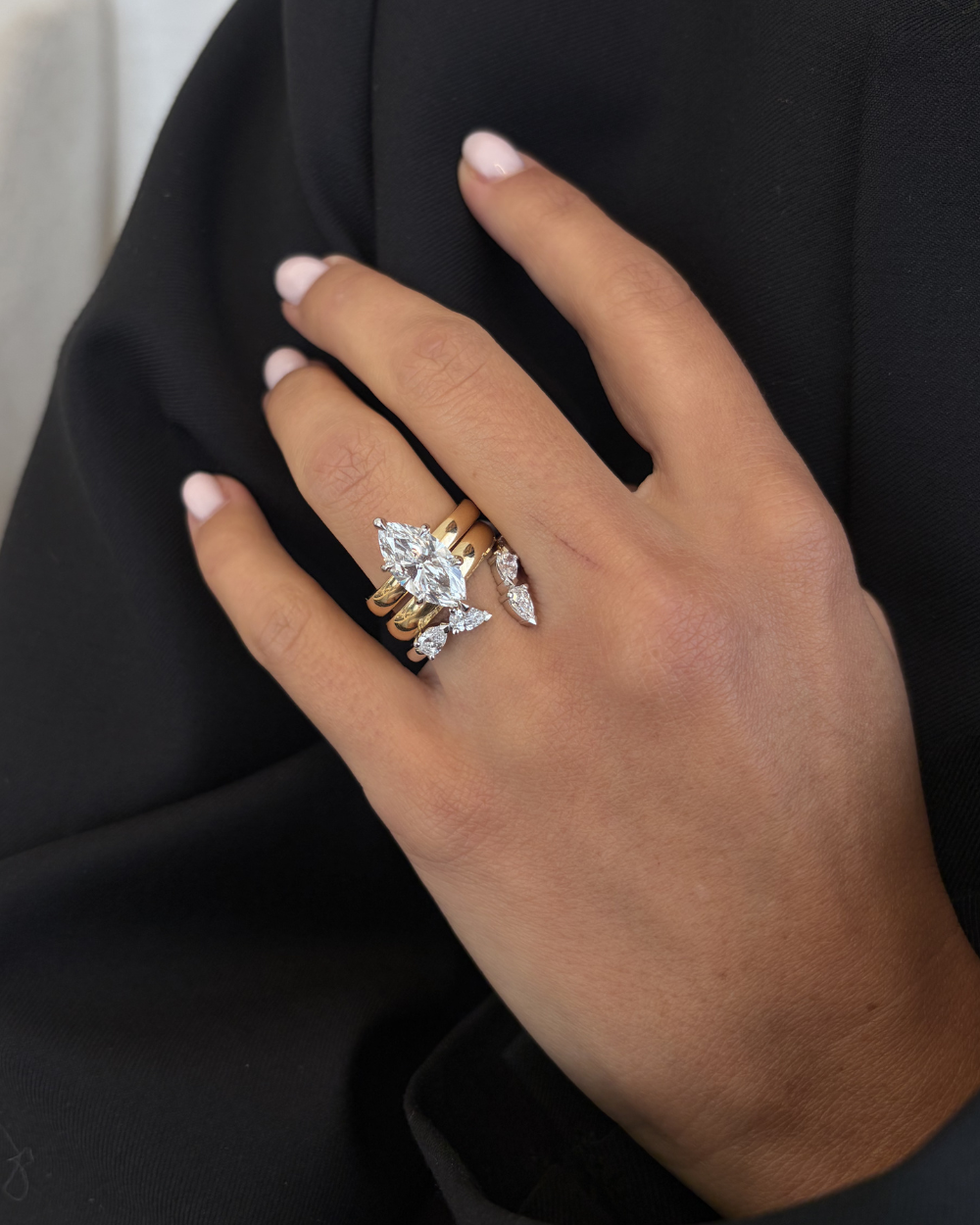 Two-tone marquise diamond engagement ring styled with matching wedding band set