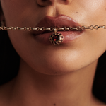 Close-up of 9ct yellow gold belcher chain with red floral pendant detail