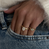 woman wearing 18ct yellow gold cushion cut diamond engagement ring on denim jeans hand