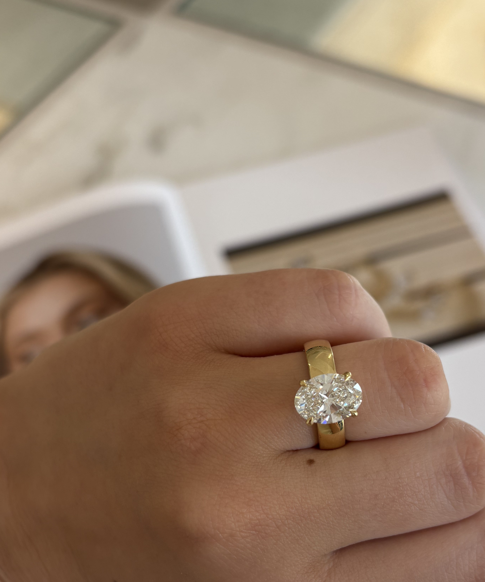 Seraphine 18ct yellow gold oval diamond engagement ring worn on finger
