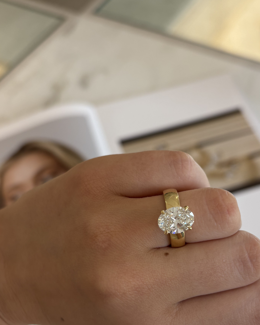 Seraphine 18ct yellow gold oval diamond engagement ring worn on finger
