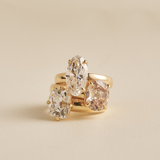 Stacked yellow gold rings featuring clear and light brown oval diamonds