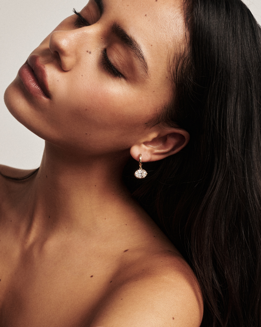oval diamond drop earrings on ear 
