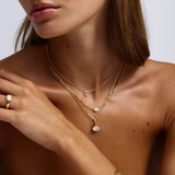 Evelyn east west diamond ring styled with layered gold necklaces and earrings