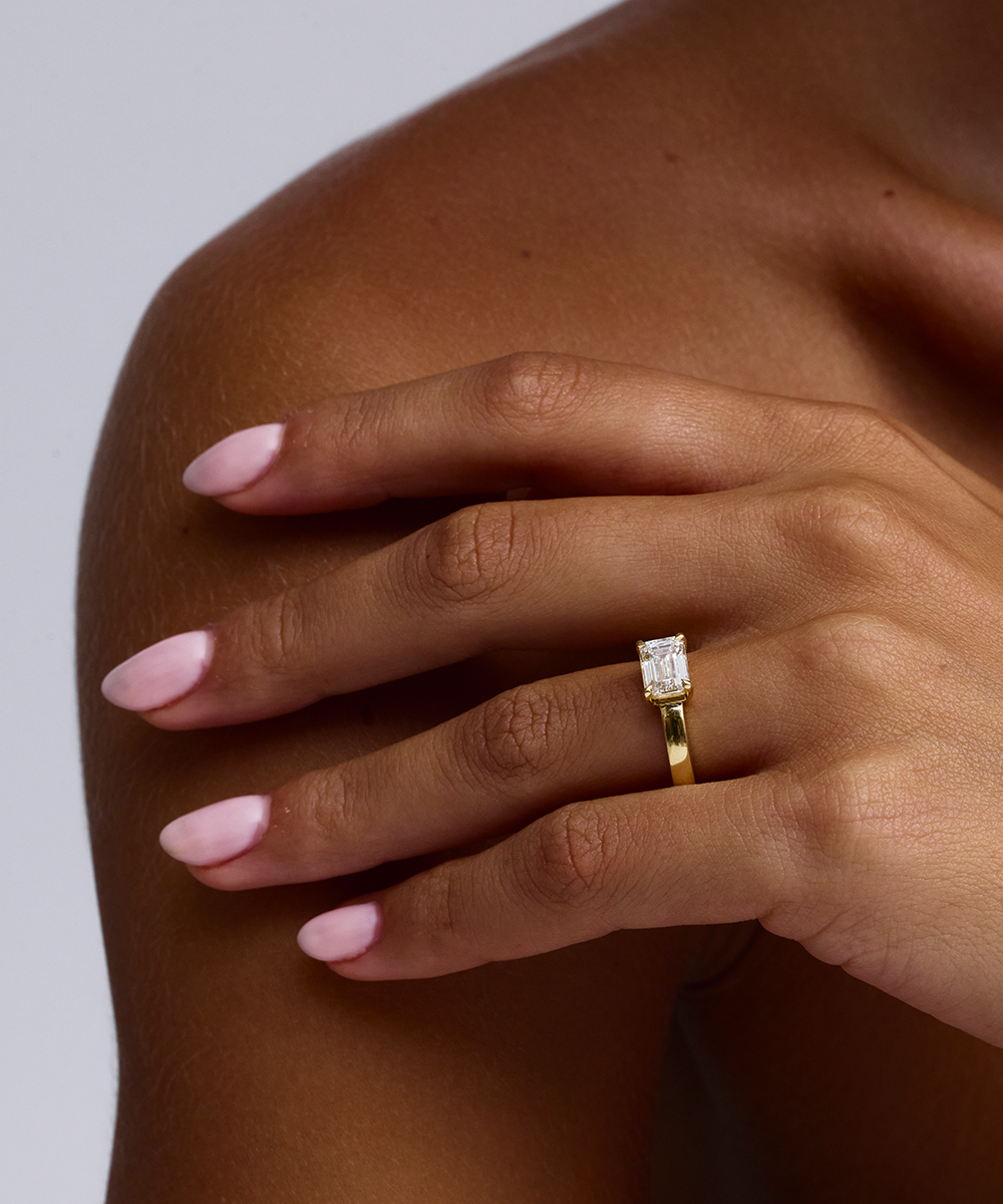 Side profile of 18ct yellow gold solitaire ring with horizontal emerald cut diamond