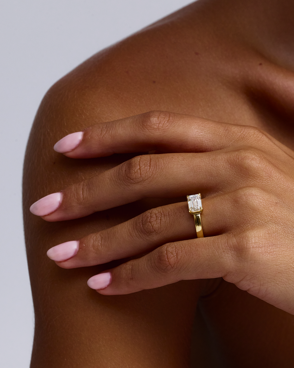 Side profile of 18ct yellow gold solitaire ring with horizontal emerald cut diamond