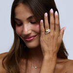 Stacked emerald cut diamond engagement ring with halo band on woman's hand