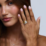 Cushion cut diamond engagement ring with matching five-stone band on right hand