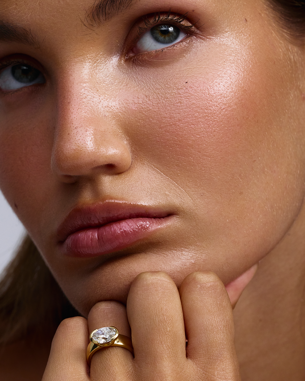 Arabella oval lab grown diamond engagement ring in 18ct yellow gold worn on hand