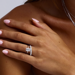 White gold emerald cut diamond ring with side diamonds on model hand
