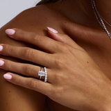White gold emerald cut diamond ring with side diamonds on model hand