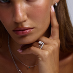 Model wearing emerald cut solitaire ring and marquise stud earrings