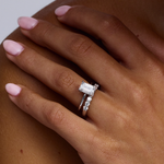 Emerald cut solitaire ring stacked with diamond wedding band profile view