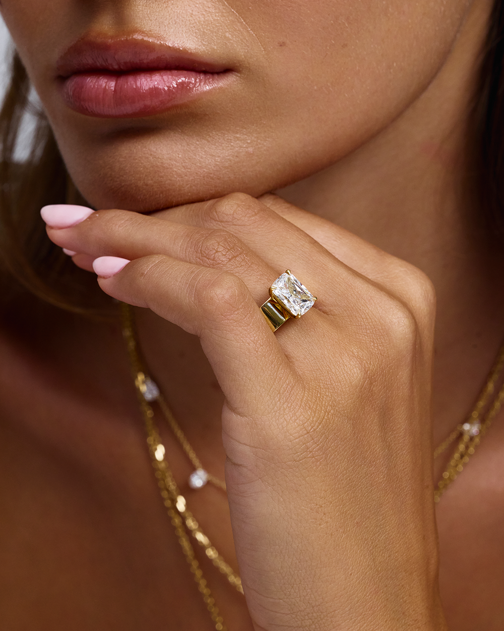 Close-up of wide 18ct yellow gold band with large emerald cut diamond centerstone