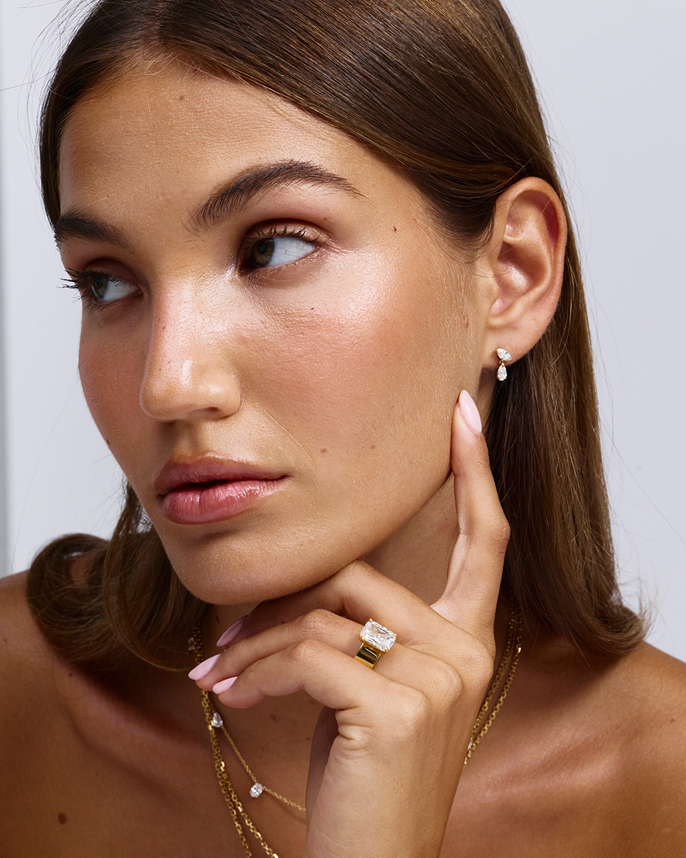 Cushion cut solitaire engagement ring paired with teardrop diamond earrings