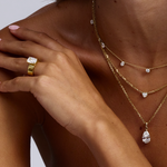 Cushion cut diamond solitaire engagement ring styled with layered gold necklaces