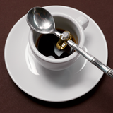 Arabella 18ct yellow gold engagement ring lifestyle shot on coffee cup handle