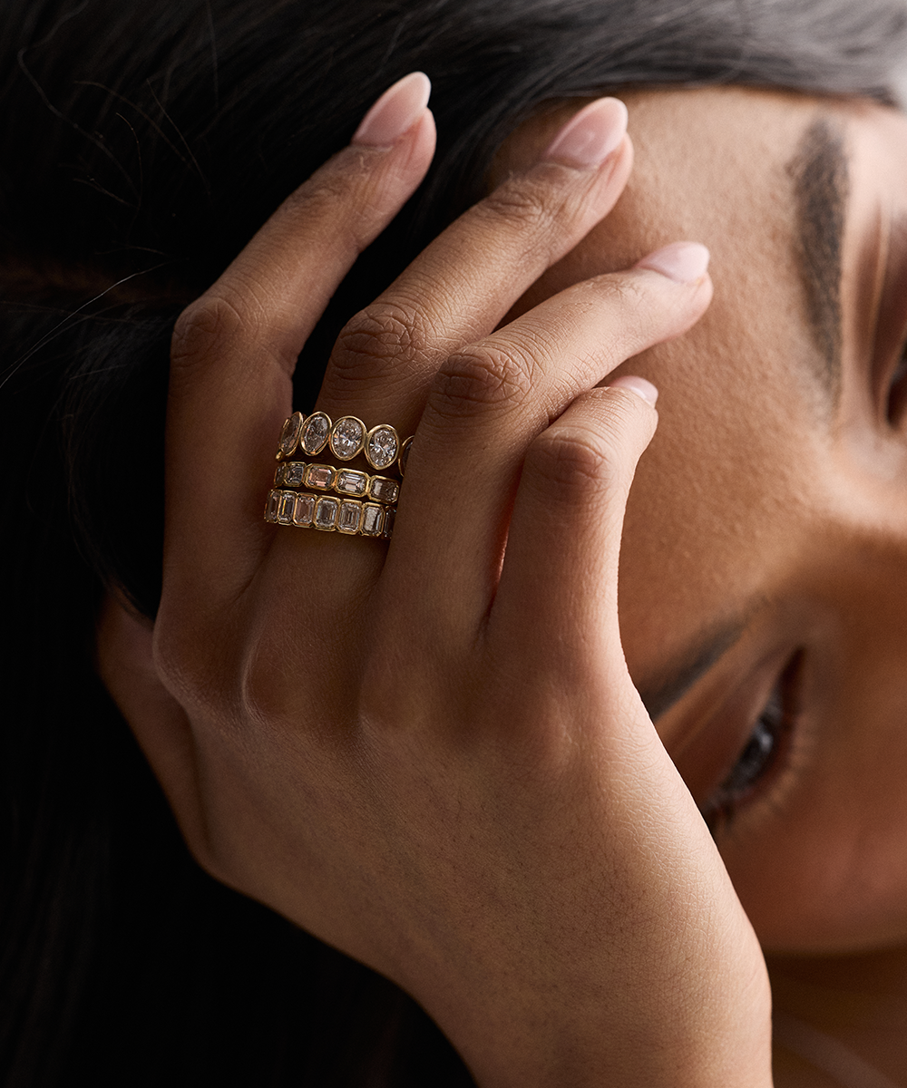 Hand wearing three stacked diamond bands with step-cut stones