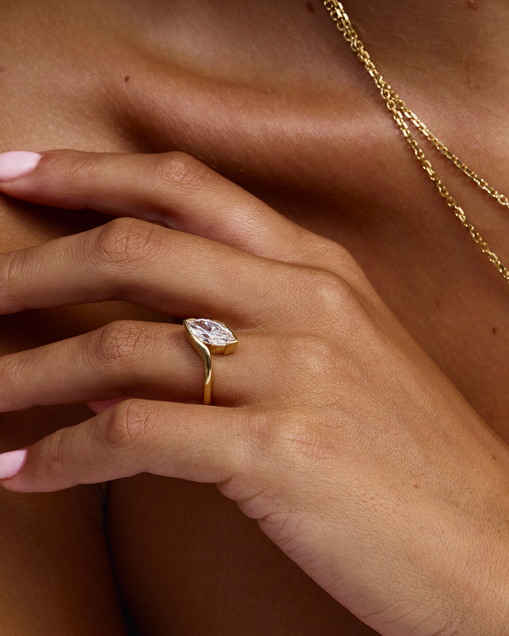 Front-three-quarter view of low-profile marquise diamond in gold wrap band