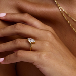 Front-three-quarter view of low-profile marquise diamond in gold wrap band