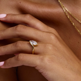 Front-three-quarter view of low-profile marquise diamond in gold wrap band