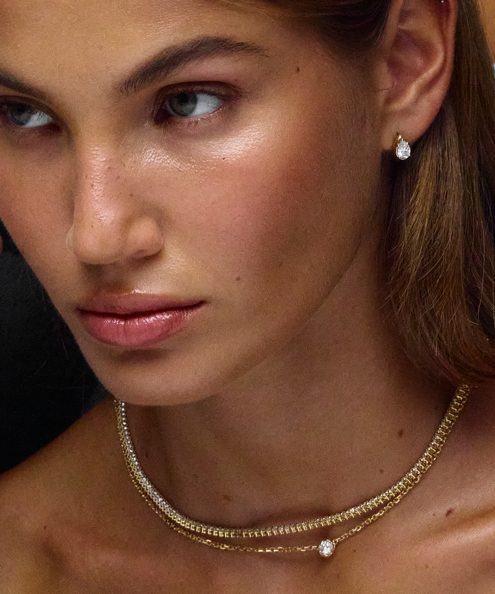 Single gold pear diamond huggie earring portrait shot